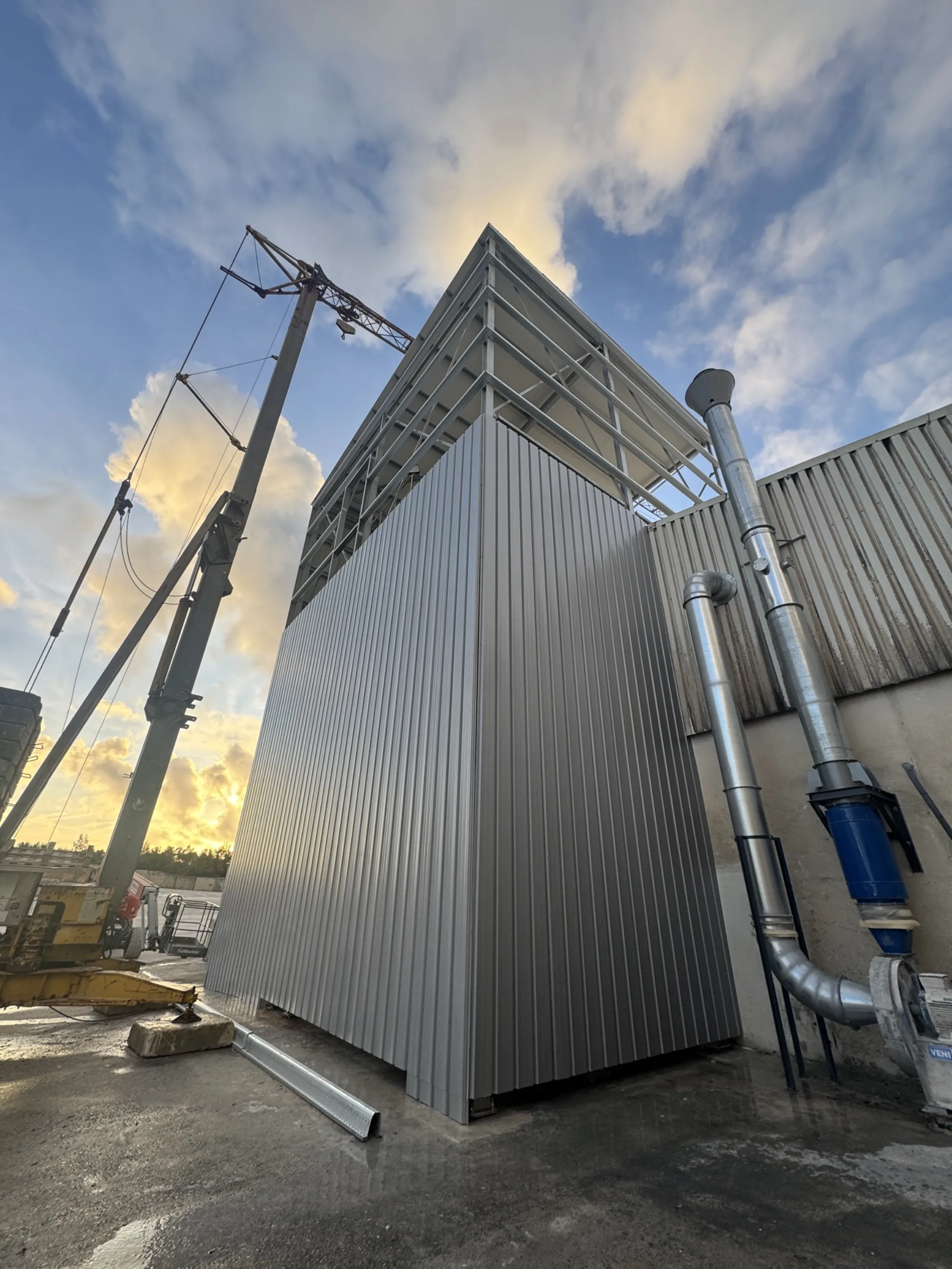 Volume técnico industrial revestido a chapa metálica, estrutura de suporte em aço à vista