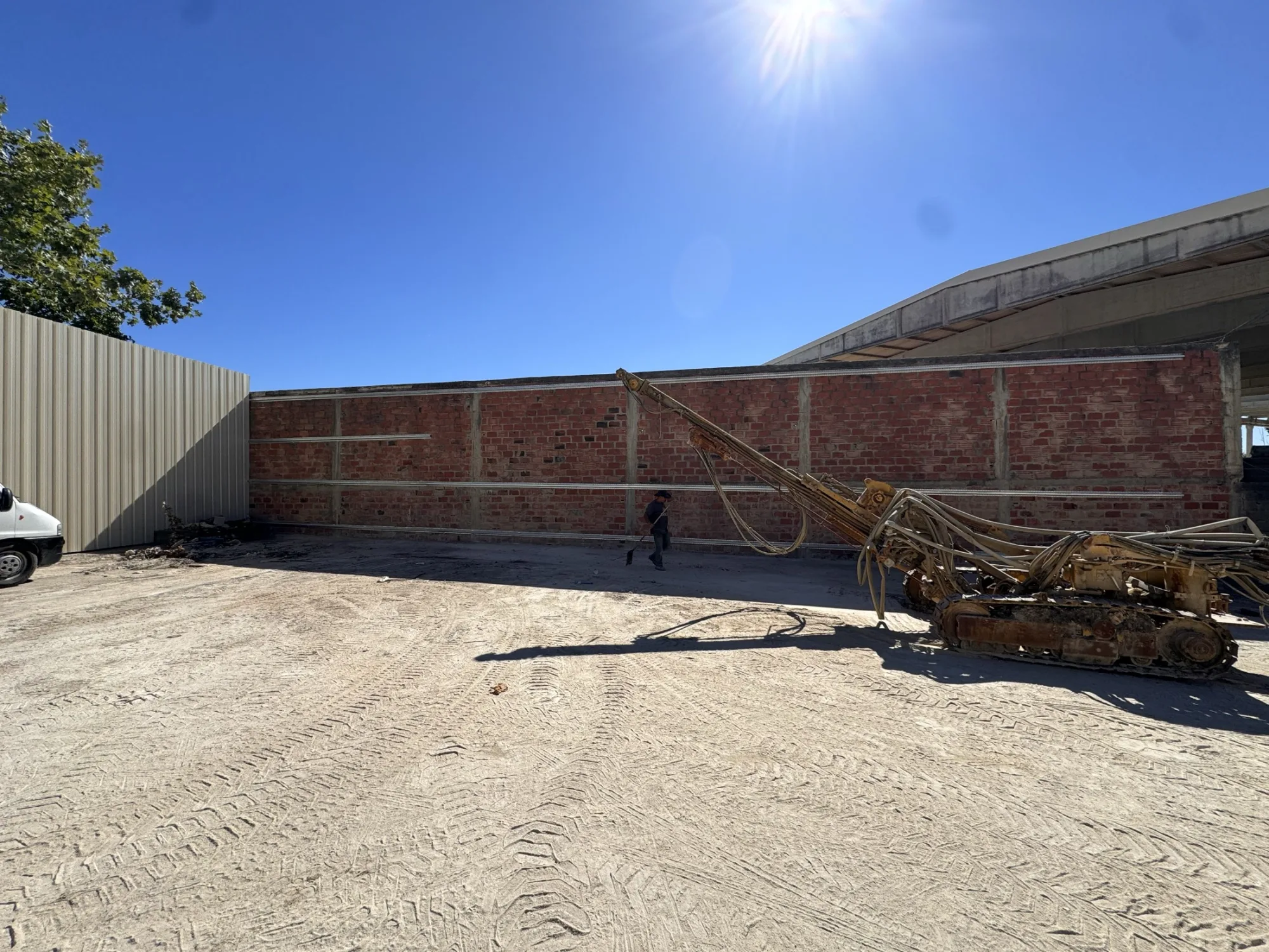 Parede de alvenaria em fase de revestimento com painel metálico